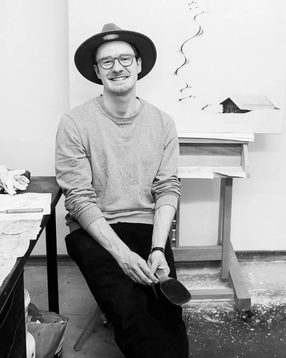 Günter Leiter in seinem Atelier, im Hintergrund ein Kohlebild